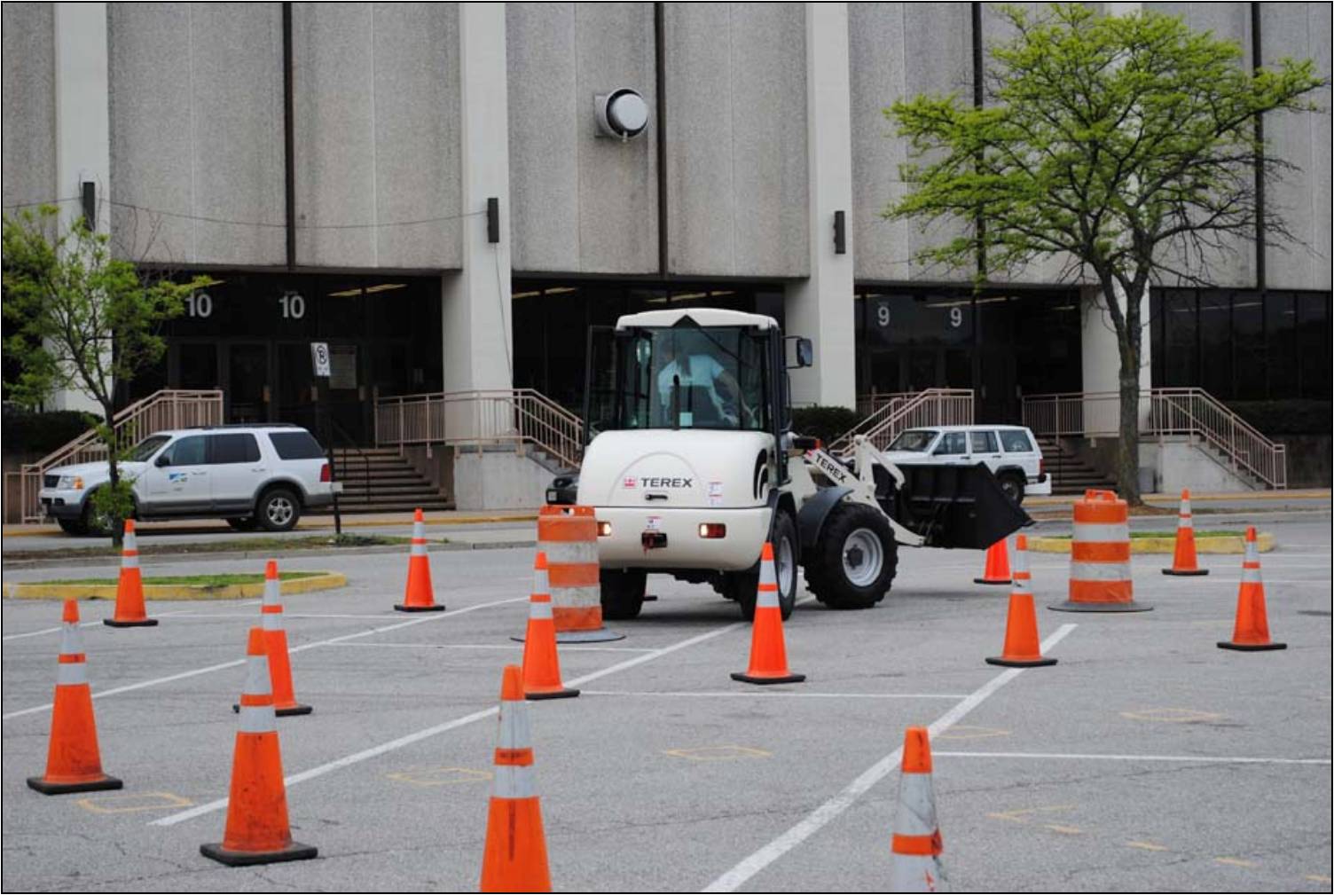 A participant from a neighboring locality carefully maneuvers the front end loader through the obstacle course.